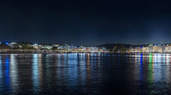 Vue nocturne de la Rade de Genève avec ses enseignes lumineuses en toiture